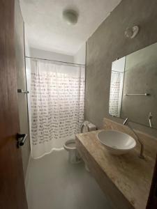 ein Badezimmer mit Waschbecken und Toilette in der Unterkunft Vila Giulia in Maresias