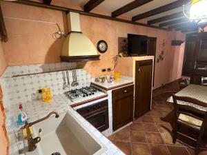 a small kitchen with a stove and a sink at Charme Rustico 70 mt from the beach, starlink in Cefalù +2 photos