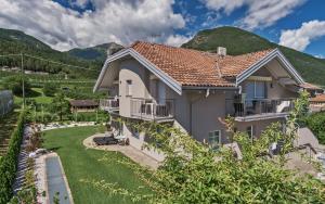 a house with a garden and mountains in the background at Ferienwohnungen Gamper in Tesimo