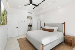 ein weißes Schlafzimmer mit einem Bett und einem Deckenventilator in der Unterkunft Encantame Soleil 1BR Sleeps 4 lock off unit in Playa Encanto