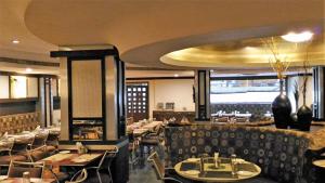 a dining room with tables and chairs in a restaurant at Taj Tristar in Hyderabad