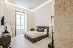 a bedroom with a bed and a large window at Dione Ortigia in Siracusa