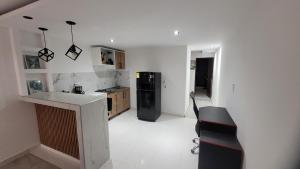 a kitchen with a black refrigerator and a white floor at Apartaestudio PA-TY in Cali +3 photos