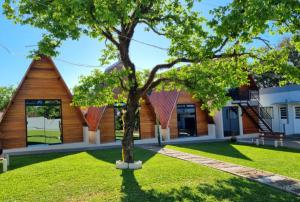 a house with a tree in front of it at Hotel Do Parque in Ijuí