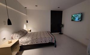 a bedroom with a bed and a desk and a window at Apartaestudio PA-TY in Cali