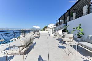 eine Reihe von Stühlen auf dem Balkon eines Gebäudes in der Unterkunft Vila VitaMaris in Okrug Donji