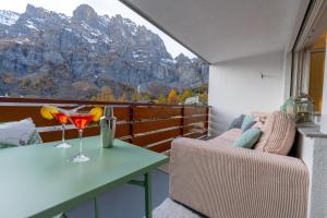 un balcon avec une table et des chaises et une vue sur la montagne dans l'établissement Le Belvédère de Loèche, à Loèche-les-Bains