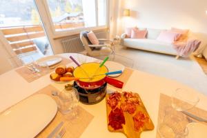 een woonkamer met een tafel met een pizza erop bij Le Belvédère de Loèche in Leukerbad