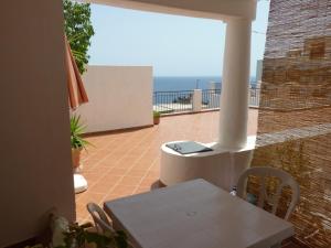 a balcony with a table and a view of the ocean at Casa Nonna Rosa in Santa Marina Salina