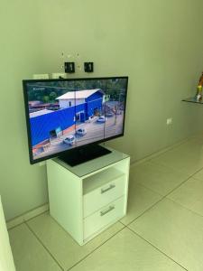 a flat screen tv sitting on a white dresser at Casa - Candeias- Jaboatão dos Guararapes in Recife