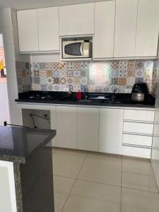 a kitchen with white cabinets and a microwave at Casa - Candeias- Jaboatão dos Guararapes in Recife