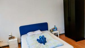 a bed with a blue headboard in a room at Eastside - Privatzimmer in geteilter Wohnung mit Gemeinschaftsbad in Stuttgart