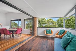 ein Wohnzimmer mit Tisch und Stühlen in der Unterkunft 27 Burrawong Drive in Port Macquarie