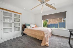 ein Schlafzimmer mit einem Bett und einem Deckenventilator in der Unterkunft 27 Burrawong Drive in Port Macquarie + 22 Fotos