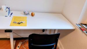 een wit bureau met een zwarte stoel in een kamer bij Eastside - Privatzimmer in geteilter Wohnung mit Gemeinschaftsbad in Stuttgart