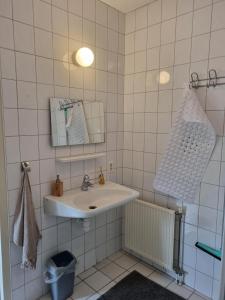 a white bathroom with a sink and a mirror at Vakantiewoning Stuifzand in Stuifzand +21 photos