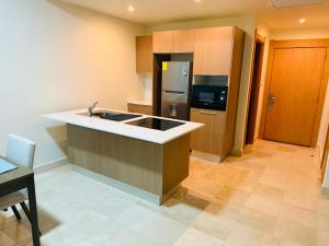 a kitchen with a sink and a refrigerator at Garden View Condo 221 Marien Beach Resort Pool Access in Puerto Plata