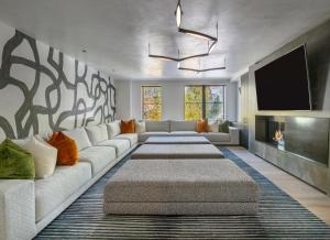 Il comprend un salon doté d'un canapé blanc et d'une télévision à écran plat. dans l'établissement Aspen St Lodge by Rove 10BR with Outdoor Amenities, à Aspen