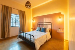 ein Schlafzimmer mit einem Bett und einem Fenster in der Unterkunft Casa céntrica con 4 habitaciones y estacionamiento in Puebla