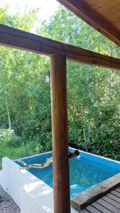 a view of a swimming pool from the porch of a house at Cabaña El Bordoneo in Villa Yacanto