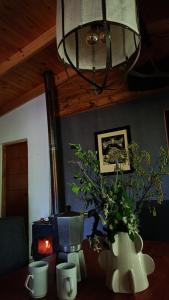 a room with a table with two vases and a lamp at Cabaña El Bordoneo in Villa Yacanto