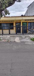 a yellow building with a black fence in front of it at CASA EN EL BARRIO CÁNDIDO CERCA AL CC ÚNICO y AL AEROPUERTO in Neiva