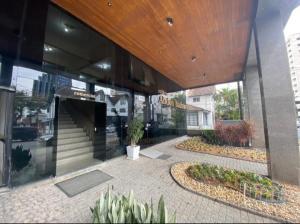 a lobby of a building with plants in front of it at Loft aconchegante no Centro in Joinville
