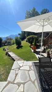 a patio with a white umbrella and a bench at La Maison del Ru - CIR VDA GIGNOD 0037 in Gignod