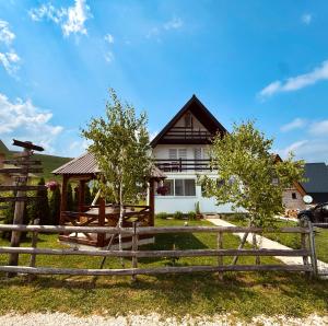 a wooden fence in front of a house at Guest House SARA in Žabljak