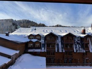 un bâtiment avec de la neige sur le toit dans l'établissement Studio apartment ASKA, à Jahorina