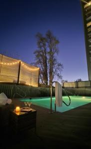 a swimming pool with a table and a white umbrella at Mirador Central Stgo 2Habitaciones 2Baños y 1Garaje in Santiago
