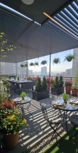 an outdoor patio with tables and chairs and plants at Mirador Central Stgo 2Habitaciones 2Baños y 1Garaje in Santiago