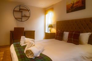 ein Schlafzimmer mit einem Bett mit Handtüchern darauf in der Unterkunft Schoolhouse 1 Cottage by Fairy Pool in Carbost