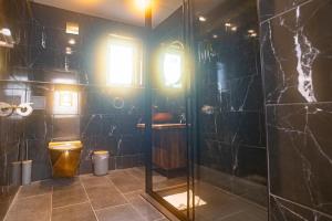 ein Badezimmer mit Glasdusche und Toilette in der Unterkunft Schoolhouse 1 Cottage by Fairy Pool in Carbost + 35 Fotos