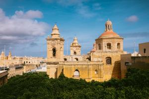 a large building with a clock tower on it at Traditional Maltese home in the three cities in Cospicua