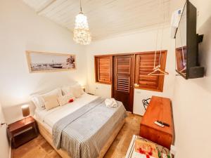 um quarto com uma cama e um lustre em AKY JERI - POUSADA Vila de Jericoacoara em Jericoacoara