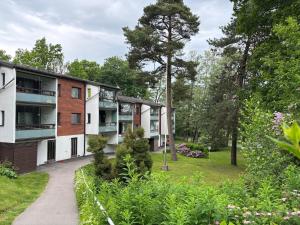 une vue extérieure d'un bâtiment avec un jardin dans l'établissement Stylish marine studio, balcony, parking in Lauttasaari, à Helsinki