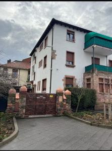 a white house with a fence in front of it at Worms City Apartment in Worms