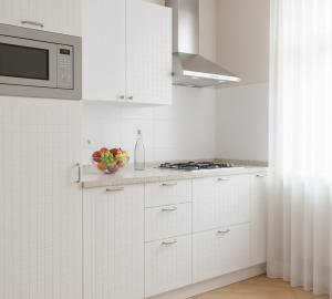 eine Küche mit weißen Schränken und einer Schale Obst in der Unterkunft Sera Apart Ayvalık in Ayvalık