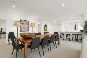 クイーンズタウンにあるTHE SHOTOVER Central Queenstown Luxuryのダイニングルーム(木製テーブル、黒い椅子付)