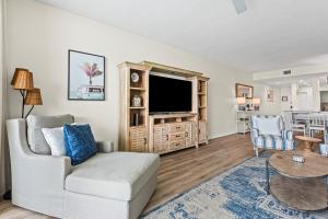 a living room with a couch and a tv at Modern Gulf Front Condo, Pool, 2 Hot Tubs, Platinum Beach Service, Endless Views in Navarre