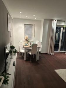 a dining room with a table and white chairs at Ferienwohnung Casa Luma in Altendiez +13 photos