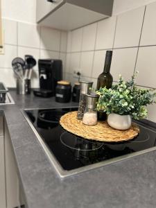 a table with a bottle of wine and flowers on a stove at Ferienwohnung Casa Luma in Altendiez