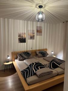 a bedroom with two beds and a chandelier at Ferienwohnung Casa Luma in Altendiez