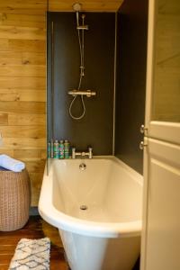 a white bath tub in a bathroom with a shower at Sky Garden Cabin - Cabin in the Clouds in Charlton Kings +34 photos