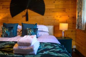 a bedroom with two beds and a table with a lamp at Sky Garden Cabin - Cabin in the Clouds in Charlton Kings