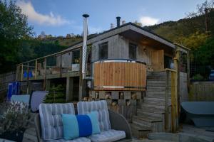 a house with a deck with a couch and a tub at Sky Garden Cabin - Cabin in the Clouds in Charlton Kings