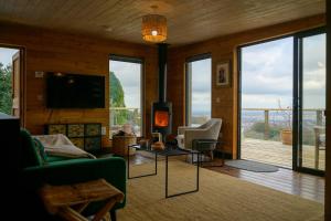 a living room with a couch and a tv and a fireplace at Sky Garden Cabin - Cabin in the Clouds in Charlton Kings