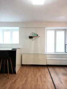 an empty room with a desk and two windows at Maison 29 in Braşov +5 photos