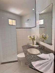 Un baño con lavabo, inodoro y espejo. en Pousada Tabatinga, en Conde 14 fotos más